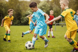 Two boys soccer teams competing for the ball during a football match Two boys soccer teams competing for the ball during a football match